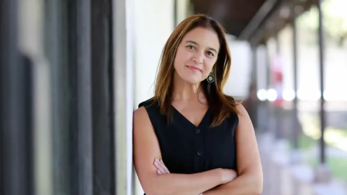 Mujer reflexionando frente a una pantalla luminosa